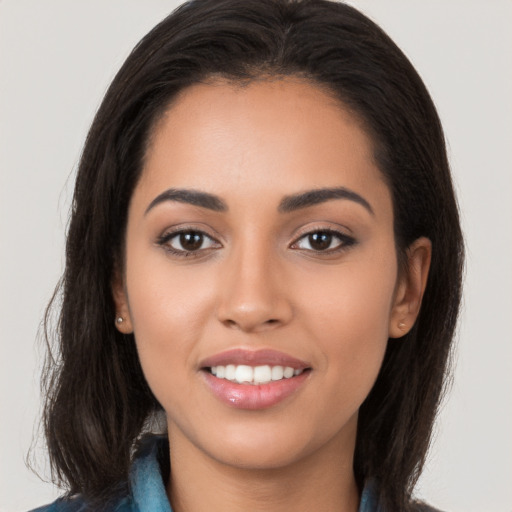 Joyful latino young-adult female with long  brown hair and brown eyes