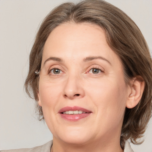 Joyful white adult female with medium  brown hair and grey eyes