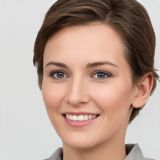 Joyful white young-adult female with short  brown hair and grey eyes