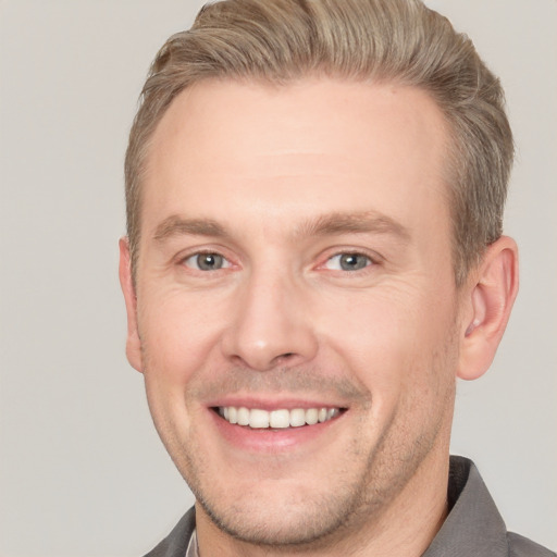 Joyful white adult male with short  brown hair and grey eyes