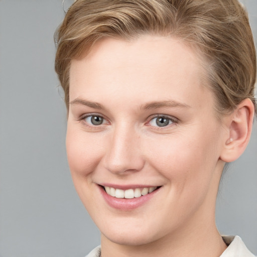 Joyful white young-adult female with short  brown hair and grey eyes