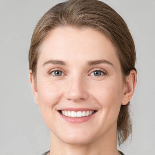 Joyful white young-adult female with medium  brown hair and grey eyes