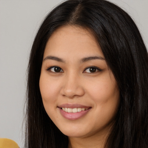Joyful white young-adult female with long  brown hair and brown eyes