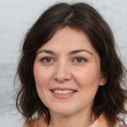 Joyful white adult female with medium  brown hair and brown eyes