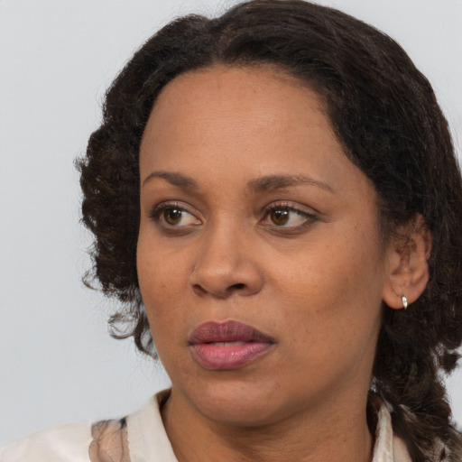 Joyful black adult female with medium  brown hair and brown eyes