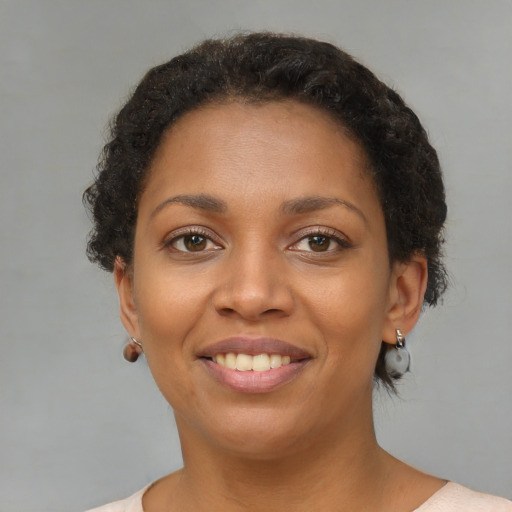 Joyful black young-adult female with short  brown hair and brown eyes
