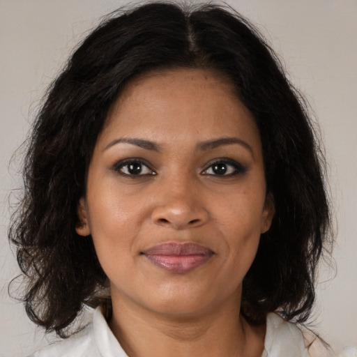 Joyful black adult female with medium  brown hair and brown eyes