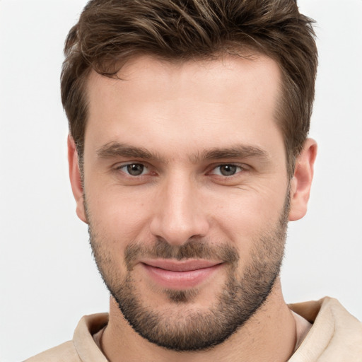 Joyful white young-adult male with short  brown hair and grey eyes