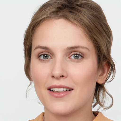 Joyful white young-adult female with medium  brown hair and grey eyes