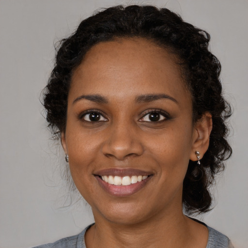 Joyful black young-adult female with medium  black hair and brown eyes