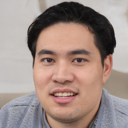 Joyful white young-adult male with short  black hair and brown eyes