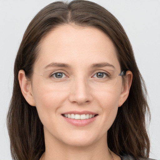 Joyful white young-adult female with long  brown hair and grey eyes