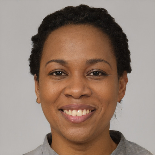Joyful black adult female with short  black hair and brown eyes
