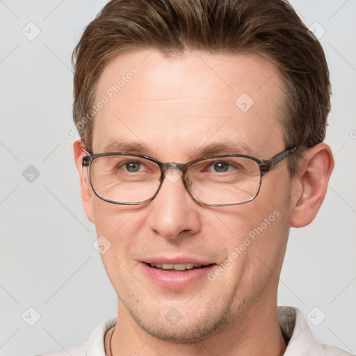 Joyful white adult male with short  brown hair and grey eyes