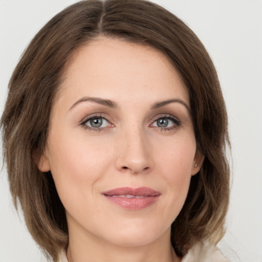 Joyful white young-adult female with medium  brown hair and grey eyes