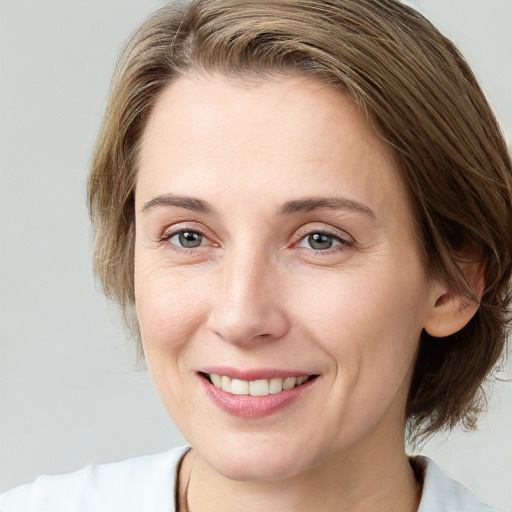 Joyful white young-adult female with medium  brown hair and grey eyes