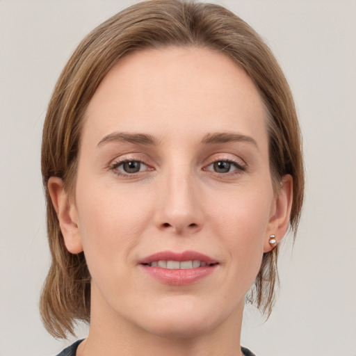 Joyful white young-adult female with medium  brown hair and grey eyes