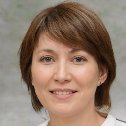 Joyful white adult female with medium  brown hair and grey eyes