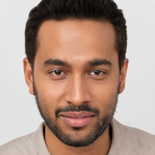 Joyful black young-adult male with short  brown hair and brown eyes