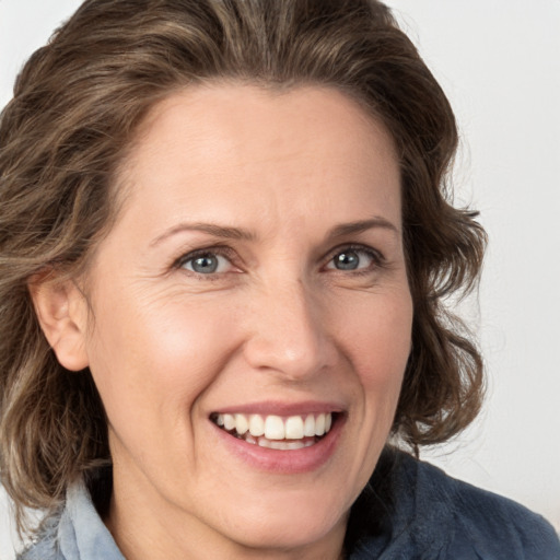 Joyful white adult female with medium  brown hair and grey eyes