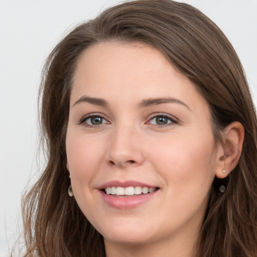 Joyful white young-adult female with long  brown hair and grey eyes