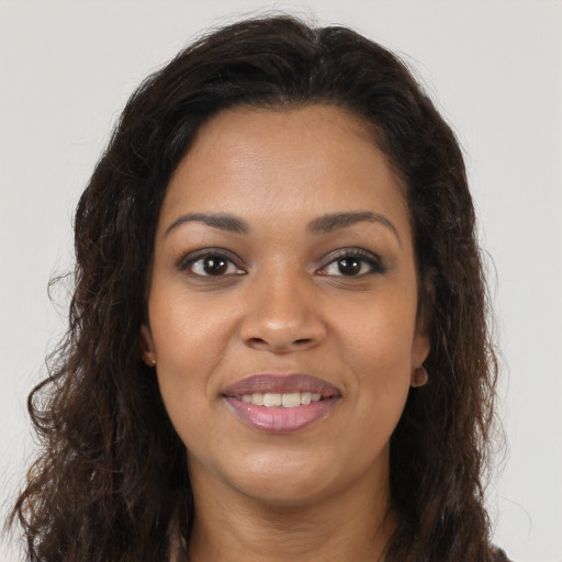 Joyful black young-adult female with long  brown hair and brown eyes