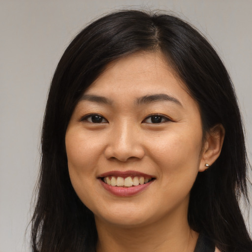 Joyful asian young-adult female with long  brown hair and brown eyes