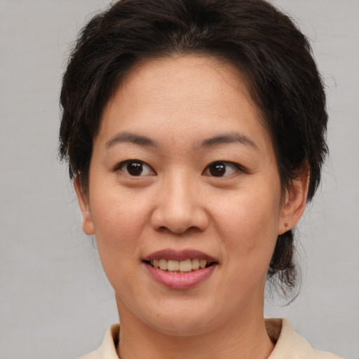 Joyful asian adult female with medium  brown hair and brown eyes