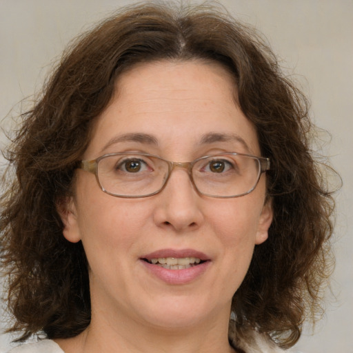 Joyful white adult female with medium  brown hair and green eyes