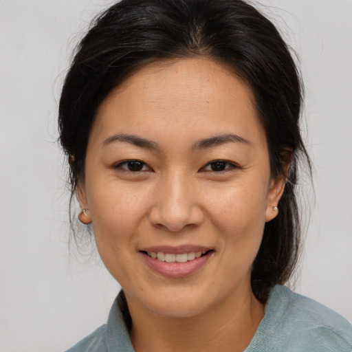 Joyful asian young-adult female with medium  brown hair and brown eyes