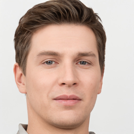 Joyful white young-adult male with short  brown hair and grey eyes