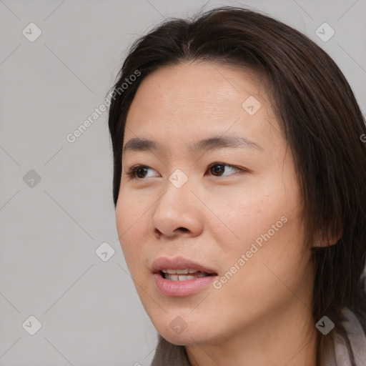 Joyful asian young-adult female with long  brown hair and brown eyes