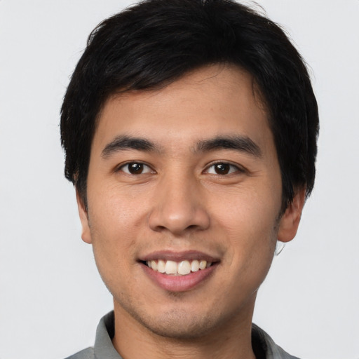 Joyful white young-adult male with short  black hair and brown eyes