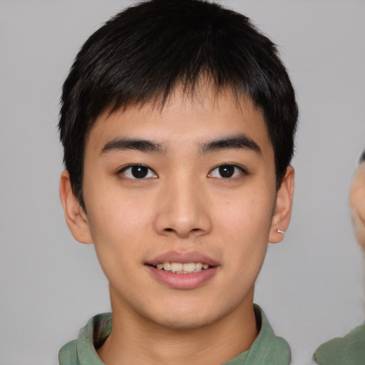 Joyful asian young-adult male with short  brown hair and brown eyes