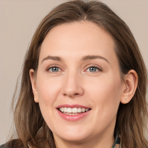 Joyful white young-adult female with long  brown hair and grey eyes