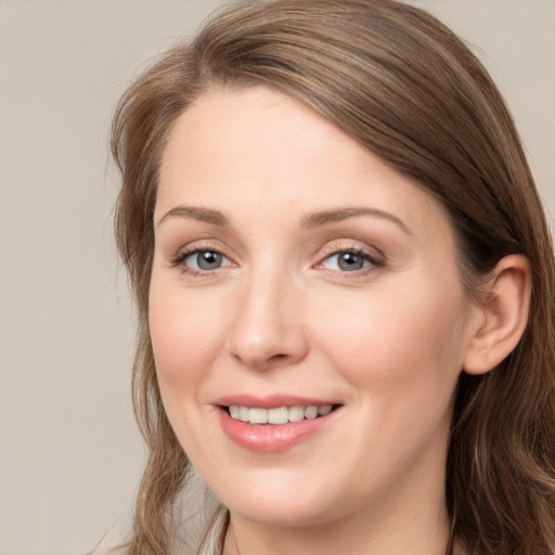 Joyful white young-adult female with long  brown hair and blue eyes