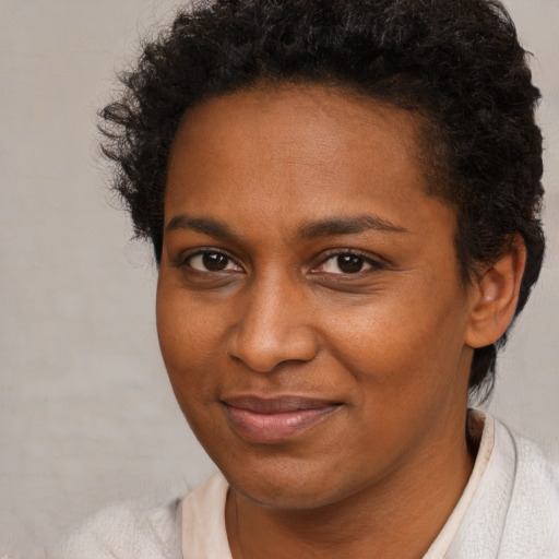 Joyful black adult female with short  brown hair and brown eyes