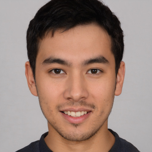 Joyful asian young-adult male with short  brown hair and brown eyes