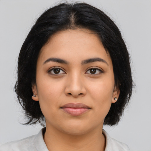 Joyful latino young-adult female with medium  black hair and brown eyes