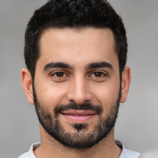 Joyful white young-adult male with short  black hair and brown eyes