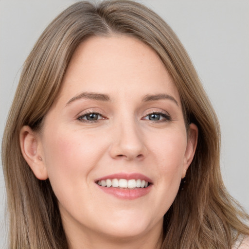 Joyful white young-adult female with long  brown hair and grey eyes