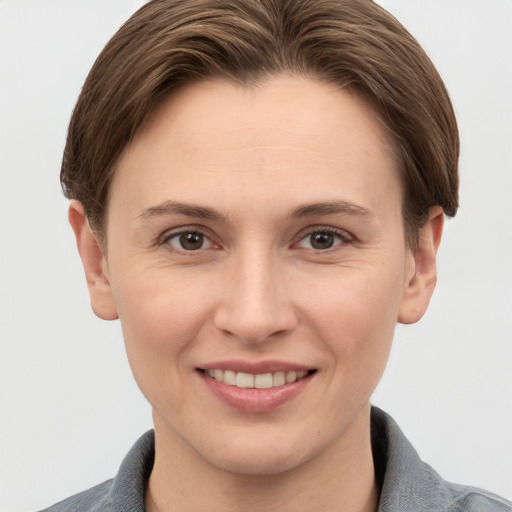 Joyful white young-adult female with short  brown hair and grey eyes