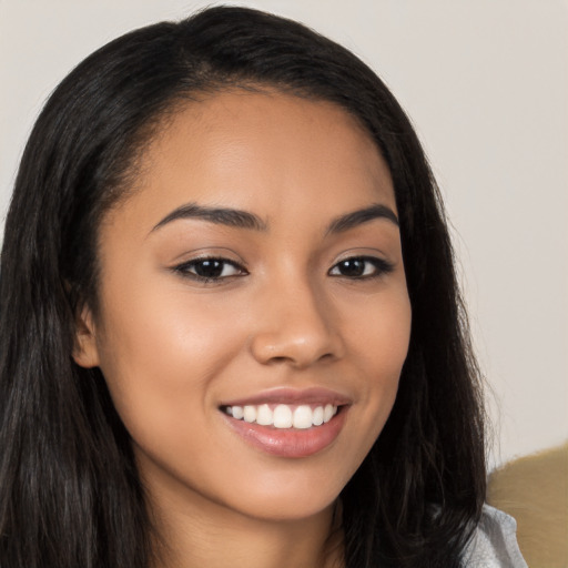 Joyful latino young-adult female with long  brown hair and brown eyes