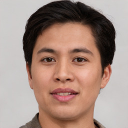 Joyful asian young-adult male with short  brown hair and brown eyes