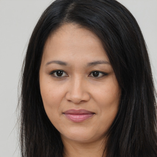 Joyful latino young-adult female with long  brown hair and brown eyes