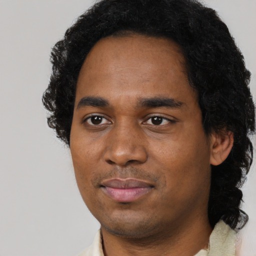 Joyful black young-adult male with short  black hair and brown eyes