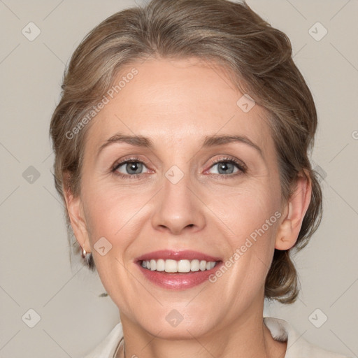 Joyful white adult female with medium  brown hair and grey eyes