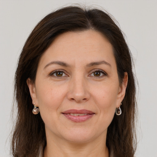 Joyful white adult female with long  brown hair and grey eyes