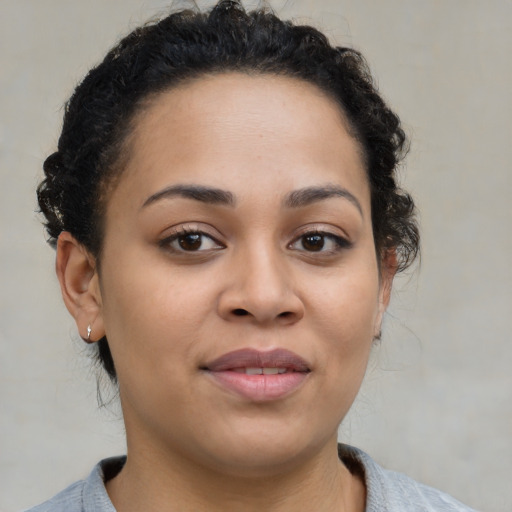 Joyful black young-adult female with short  brown hair and brown eyes