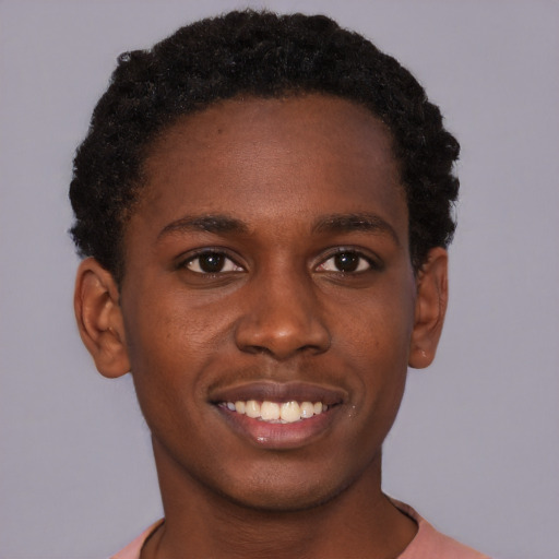 Joyful black young-adult male with short  brown hair and brown eyes